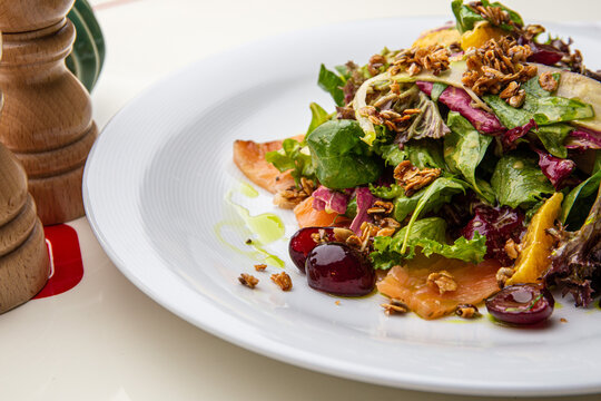 Green salad with salmon, lettuce, cherries, nuts