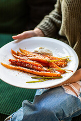 Girl holding a dish with baked sweet potato in her hands