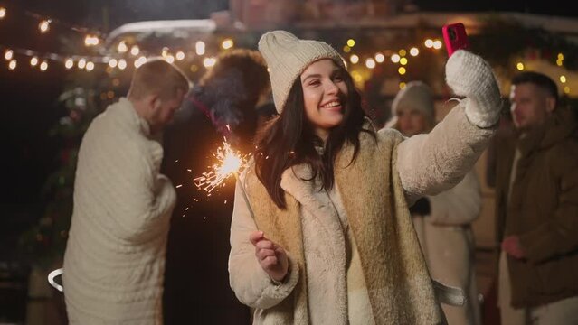 beautiful woman takes selfie in merry Christmas party with friends, take photo face and sparkler