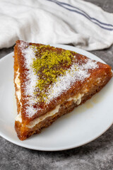 Bread kadayif dessert with cream on a dark background. Turkish cuisine desserts. close up