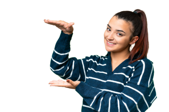 Young beauty woman over isolated chroma key background holding copyspace to insert an ad