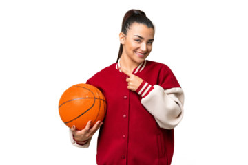 Young Woman playing basketball over isolated chroma key background pointing to the side to present a product