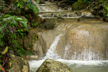 Fototapeta na wymiar Enchanting waterfall with gentle flowing water on a big rock