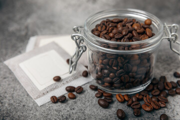 Drip coffee bag and coffee beans, ground coffee for brewing in a cup, paper bag drip coffee filter packaging. composition on a black marble texture table.MOCAP. The concept of brewing a drink.