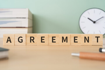 AGREEMENTと書かれたブロックが置かれたデスク