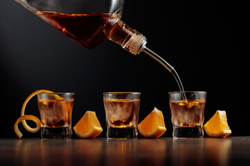Old-fashioned cocktail with ice and orange.