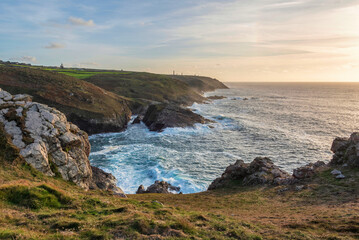 Fototapeta na wymiar Stunning sunset landscape image of Cornwall cliff coastline with tin mines in background viewed from Pendeen Lighthouse headland