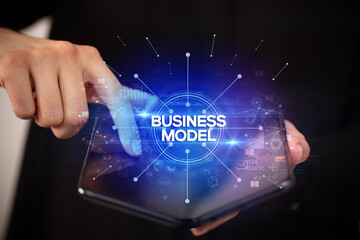 Fototapeta premium Businessman holding a foldable smartphone, new business concept
