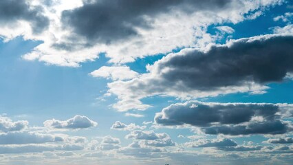 White fluffy clouds slowly float through the blue daytime sky timelapse. Beautiful skies are moving. Airy snow-white clouds move to the side.
