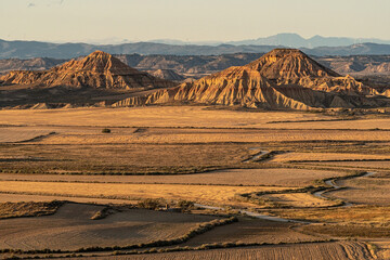 Rock formations in desert area of Las Bardenas Reales in Navarra at sunset from viewpoint, Spain