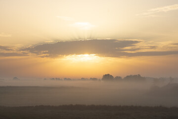 Landschaft bei Sonnenaufgang im Nebel, weite Aussicht