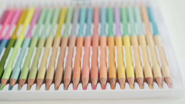 Colorful crayons on white table closeup. Palette of drawing pencils on desk