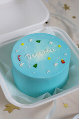 small blue bento cake with christmas decor and text december