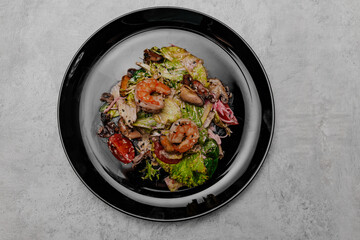 Salad with seafood on a gray background. View from above.
