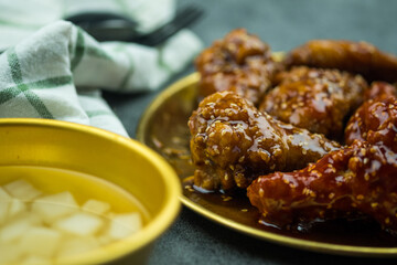 Deep fried chicken wing with garlic sauce and spicy sauce in Korean style served with pickled radish, Asian food concept.