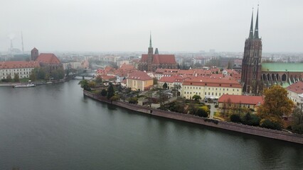 Fototapeta na wymiar Aerial view of Odra river in Wroclaw with old church, bridge and old town covered by foggy whether