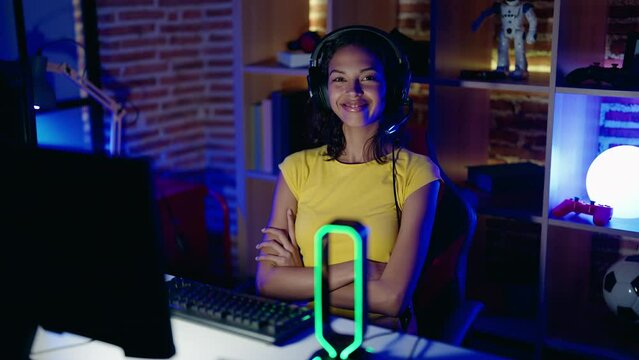 Young african american woman streamer smiling confident sitting with arms crossed gesture at gaming room