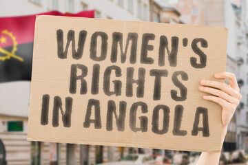 The phrase " Women's rights in Angola " is on a banner in men's hands with blurred background. Cheering. Community. Confidence. Courage. Crowd. Defend. Determination. Different. Diversity. Fight