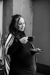 Pregnant business woman drinking coffee at the cafe