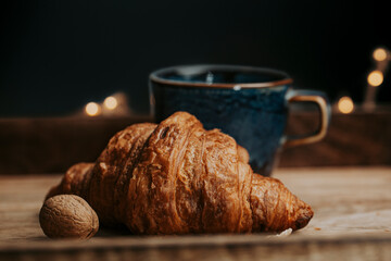 Cup of coffee with croissant with walnuts - evening in the cafe