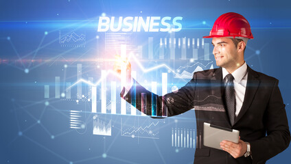 Young businessman with helmet drawing on virutal screen