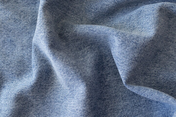 Blue jeans background carelessly thrown. Denim detail. Fabric gathered in folds