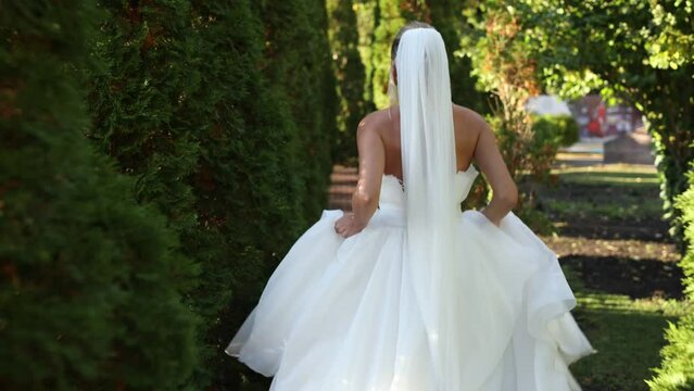 bride is running in the park in a wedding dress
