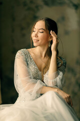 a girl in a dress against a shabby wall