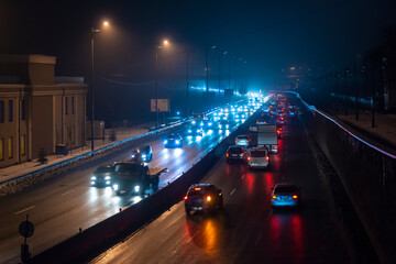 Fototapeta na wymiar Car lights in the night foggy city.