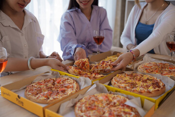 Close up hands get slice of pizza, Group of young asian office girl friends having fun and celebrating pizza on table during party