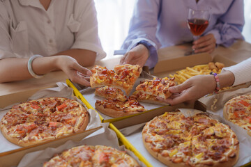 Close up hands get slice of pizza, Group of young asian office girl friends having fun and celebrating pizza on table during party