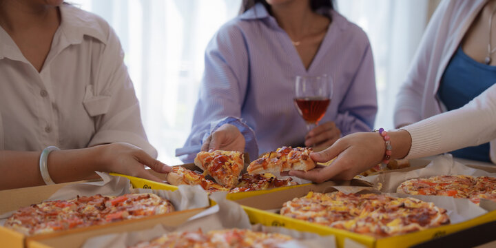 Close up hands get slice of pizza, Group of young asian office girl friends having fun and celebrating pizza on table during party