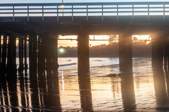 The setting sun is being reflected in the water behind the Santa Cruz Wharf.
