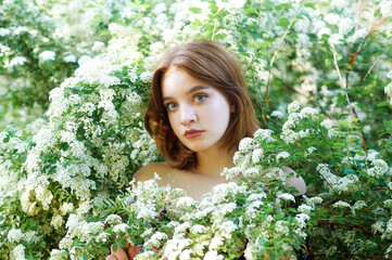 Young beautiful girl on a summer day among flowering trees - 552810867
