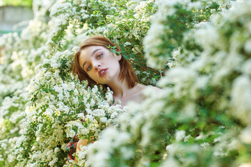 Young beautiful girl on a summer day among flowering trees - 552810895