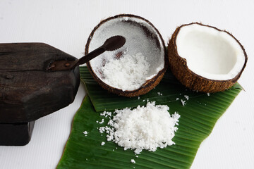 Closeup Coconut grater tool, coconut shell on green banana leaves, prepare coconut milk for food or...