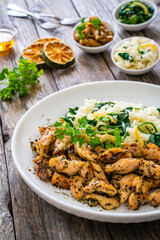 Fried chicken nuggets with white rice and spinach on wooden table
