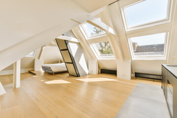 an attic style room with wood floors and skylights on the roof, looking towards the living area to...