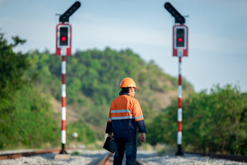 Engineer under inspection and checking construction process railway switch and checking work on railroad station .Engineer wearing safety uniform and safety helmet in work