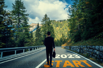 The 2023 New Year journey and future vision concept . Businessman traveling on highway road leading forward to happy new year celebration in beginning of 2021 for fresh and successful start . - obrazy, fototapety, plakaty