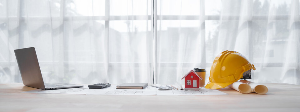 Red color House toy model with Solar Powered, engineering architect blueprint, Solar and Green Energy concept.