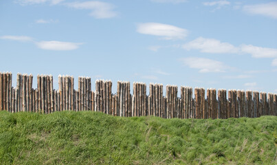 Fototapeta na wymiar Wooden fence against the sky, the protection of the fortress.