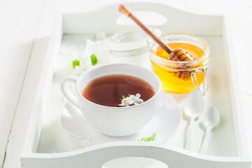 Hot tea with honey in white ceramics.