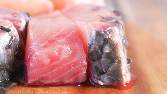 Fresh boneless skinless cod filet on chopping board 