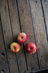 Ripe juicy apples on a wooden background.