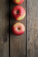 Ripe juicy apples on a wooden background.