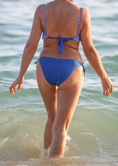 Fototapeta premium Girl in a swimsuit on the seashore.