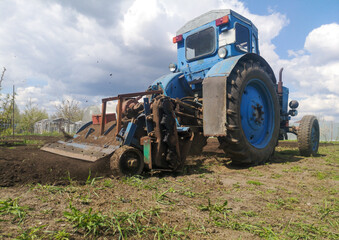 The tractor plows the soil on the field