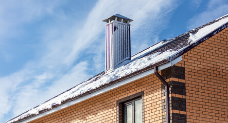 Snow on the roof of the house.