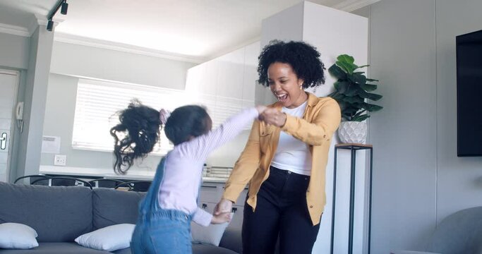 Active Happy African Mom And Cute Little Kid Daughter Jumping Dancing At Home, Carefree Funny Black Family Mother Having Fun With Small Child Girl Laughing Do Morning Exercise Together In Living Room